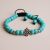Handmade in Nepal by skilled artisans, this turquoise stone wrist mala features the Endless Knot, symbolizing interconnectedness and serving as a companion on your spiritual journey.