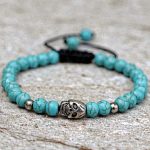 Handmade in Nepal by skilled artisans, this Turquoise Stone Wrist Mala features a white metal skull bead, symbolizing transformation and protection, guiding your spiritual journey with clarity and courage.