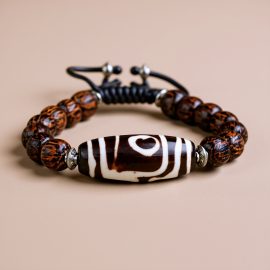 Handmade in Nepal by skilled artisans, this Dzi Bead Palm Wood Wrist Mala aids in spiritual growth and emotional balance, guiding you towards inner peace and clarity.