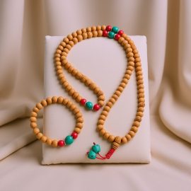 Handmade in Nepal by skilled artisans, this Light Brown Sandalwood Japa Mala and Wrist Mala/Bracelet Set features calming sandalwood and vibrant coral, fostering peace and spiritual connection.