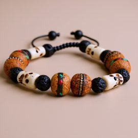 Handmade in Nepal by skilled artisans, this natural wood wrist mala features skull beads, symbolizing impermanence and providing spiritual protection while fostering emotional balance and tranquility.