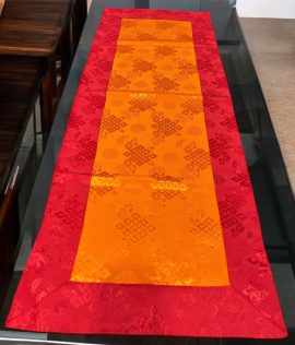 This handmade Tibetan Buddhist table runner, crafted from silk brocade in Nepal, features the endless knot design, symbolizing the unity of wisdom and compassion, enriching your sacred space.