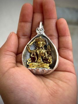 This handmade Manjushri pendant from Nepal embodies the wisdom of the Bodhisattva, guiding its wearer on the path to enlightenment with its delicate design.