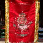 This handmade Tibetan door hanging from Nepal, adorned with the eight auspicious symbols, invites blessings and positive energy into your space, connecting the physical and spiritual realms.