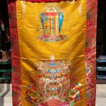 This handmade Tibetan door curtain, crafted from silk brocade in Nepal, features the Kalachakra and eight auspicious symbols, inviting blessings and protection into your sacred space.