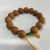 This handmade Bodhi seed wrist mala from Nepal features 14 sacred beads, serving as a spiritual companion for prayer and meditation, symbolizing enlightenment and the journey to liberation.
