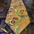 This handmade Tibetan table runner from Nepal features a golden flower design and five colorful tassels, creating a harmonious space for meditation and spiritual offerings.