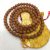 This handmade Bodhi seed mala, crafted by skilled artisans in Nepal, features 108 prayer beads, symbolizing enlightenment and serving as a sacred tool for mantra counting.