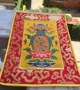 This handmade Tibetan Auspicious Symbol Placemat, crafted in Nepal, serves as a sacred space for meditation, embodying blessings through the eight auspicious symbols.