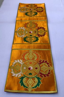 This handmade yellow double dorje placemat from Nepal enriches your shrine, providing a sacred space for prayer and meditation while enhancing your spiritual practice and home aesthetics.