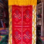 This handmade Tibetan door curtain, crafted in Nepal by skilled artisans, features the Endless Knot symbolizing interconnectedness, inviting blessings and harmony into your sacred space.