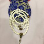 This handmade Tibetan conch shell mala, crafted in Nepal, features 108 beads symbolizing the Buddha's teachings, accompanied by a serene Buddha face, embodying the essence of spiritual truth.