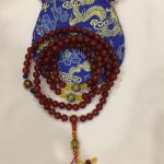 This handmade carnelian mala from Nepal features 108 beads with sacred mantra spacers, guiding the wearer towards confidence and positivity on their spiritual journey.