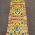 This handmade table runner from Nepal features the Tibetan double dorji design, embodying Vajrayana spirituality and inviting peace into your meditation space with its vibrant yellow color.