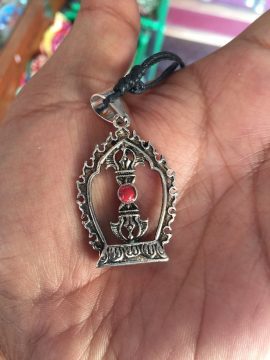 This handmade Dorji Kalachakra pendant, crafted by skilled artisans in Nepal, symbolizes spiritual protection and wisdom, guiding the wearer on their journey through Vajrayana Buddhism.