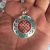 This handmade Tibetan Endless Knot pendant from Nepal, adorned with turquoise and coral, symbolizes the interconnectedness of all life, guiding the wearer towards wisdom and compassion.