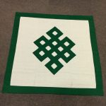 This handmade table cover from Nepal, adorned with the Tibetan endless knot, symbolizes the unity of all things and enhances your sacred meditation space.