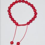 This handmade Coral Glass wrist mala, crafted by skilled artisans in Nepal, features 22 beads and serves as a supportive tool for meditation and travel, enhancing emotional balance.