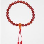 This handmade Carnelian mala, crafted in Nepal by skilled artisans, features 27 beads and a guru bead, supporting meditation and spiritual practice with its grounding energy.