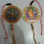 This handmade Tibetan Manjushri car hanging from Nepal embodies wisdom and protection, featuring Manjushri&rsquo;s serene image and sacred mantra, inviting blessings and good fortune into your space.