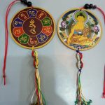 This handmade car hanging features Shakyamuni Buddha, inviting peace and protection. Crafted by skilled artisans in Nepal, it carries a sacred mantra, enhancing its spiritual essence.