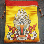 This handmade mala bag, crafted from silk brocade by skilled artisans in Nepal, embodies Tibetan spirituality while serving as a versatile pouch for prayer beads, coins, or jewelry.