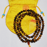 Handmade in Nepal by skilled artisans, this Tiger's Eye mala features 108 beads, enhancing protection, willpower, and prosperity on your spiritual journey. A meaningful companion for life&rsquo;s path.