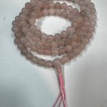 Handmade in Nepal by skilled artisans, these rose quartz mala beads support meditation, nurturing compassion and inner peace while enhancing the heart chakra's gentle energy.