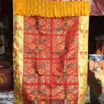 This handmade Tibetan door curtain, crafted by skilled artisans in Nepal, features the Double Dorje, symbolizing the union of wisdom and compassion, enhancing the spiritual atmosphere of any space.