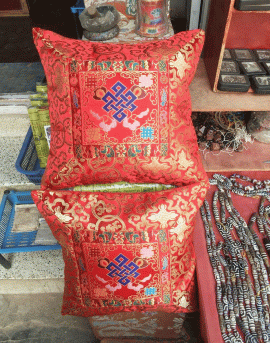 This handmade Tibetan silk brocade cushion cover, crafted in Nepal, features the Endless Knot, symbolizing unity and harmony, bringing sacred beauty to your home.