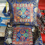 This handmade silk brocade cushion cover from Nepal features a double dorje design, symbolizing the indestructible nature of enlightenment, enriching your space with sacred energy.