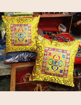 This handmade Tibetan cushion cover, crafted by skilled artisans in Nepal, features a vibrant yellow double dorje, symbolizing the harmony of wisdom and compassion for your meditation space.