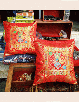 This vibrant silk brocade cushion cover, adorned with a sacred double dorje design, is handmade in Nepal by skilled artisans, bringing mindfulness and tranquility to your space.