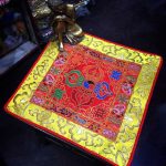 This handmade Tibetan altar cloth, crafted by skilled artisans in Nepal, harmoniously blends the dorje and lotus, embodying the union of wisdom and compassion for your sacred space.