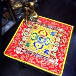 This handmade Tibetan altar cloth, crafted from thick yellow silk brocade by skilled artisans in Nepal, embodies the sacred symbols of the dorje and lotus, enhancing your meditation space.