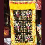 This handmade Tibetan door curtain, featuring a Mahakala design, is crafted in Nepal by skilled artisans, inviting blessings and protection into your sacred space.